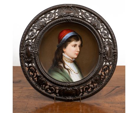 A German painted-pottery dish Decorated with the head and shoulders of a girl, set within a cast bronze frame with pierced de