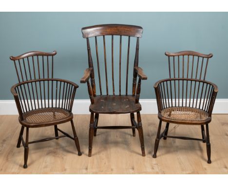 A group of three chairs Two consist of a pair of stick-back Windsor-style armchairs with wicker seats, and a lathe-back open 