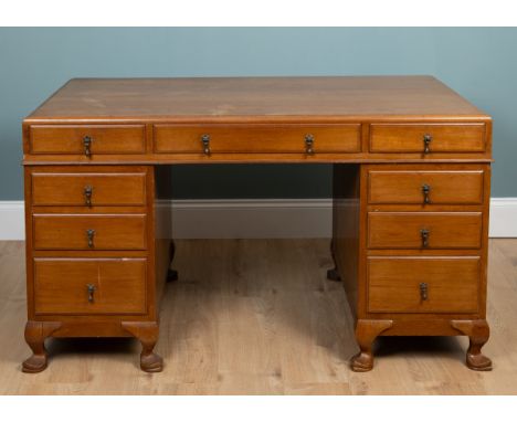 A teak pedestal desk With a caddy top and exposed dovetail joints, the desk with three drawers over a kneehole and flanked by