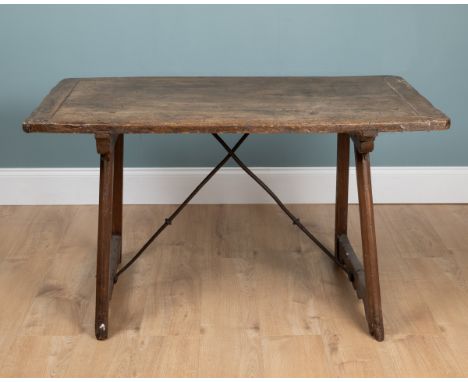 An antique Spanish centre table The walnut table with trestle supports and wrought iron braces.126cm wide x 73cm deep x 72cm 