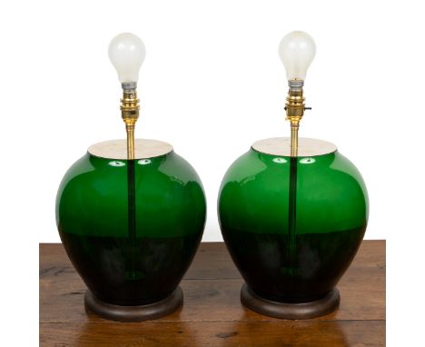 A pair of green glass table lamps The lamps of bulbous form with grey shades.37cm high to the fittingQty: 2In generally good 