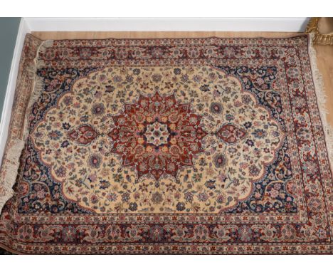 A 20th century rug, possibly by Axminster Carpets In the Kashan style with a red central medallion, cream ground, and all-ove