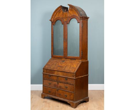 A Queen Anne burr walnut and oak bureau bookcase The bookcase with a broken arch pediment above mirrored twin-panelled doors 