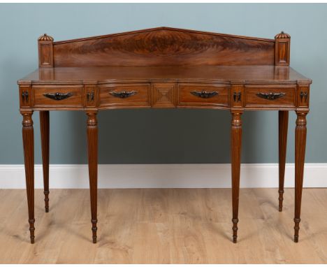 A Georgian mahogany sideboard in the Egyptian style  With ebony carved mounts and an inverted bow front raised on reeded tape