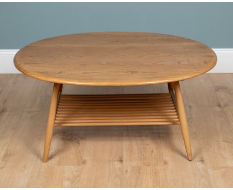 An Ercol blond elm coffee table With a circular top standing on outsplayed legs united by an undertier.100cm wide x 84cm deep