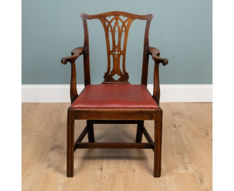 A Georgian Chippendale-style mahogany elbow chair With a red leather drop-in seat, standing on square section legs united by 