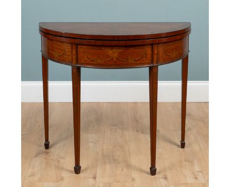 A George III satinwood, inlaid demi-lune card table The top opening to reveal a green baize inset, the frieze inlaid with rib