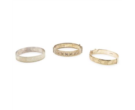 A 9ct bangle of hinged design with bright cut foliate detail, together with a hinged silver and silver gilt bangle (3) . (Dim