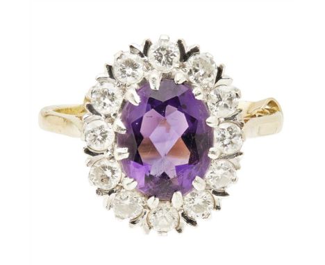 An amethyst and diamond set cluster ring claw set with an oval cut amethyst in a border of round brilliant cut diamonds, to a