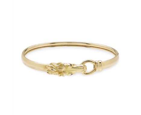 A modern bangle of plain design with horse head detail, small ruby set eyes, stamped 750 (Dimensions: Diameter: 63mm)(Diamete
