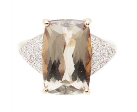 A tourmaline and diamond set ring claw set with a yellowish-green cushion cut tourmaline, the triangular shoulders and galler