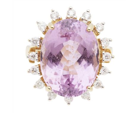 A kunzite and diamond set cocktail ring claw set with a large oval mixed cut pink kunzite, in a border of round brilliant cut