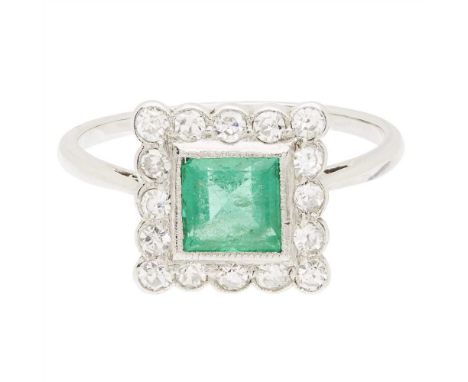An emerald and diamond set cluster ring millegrain set with a square cut emerald, in a single border of eight-cut diamonds, t