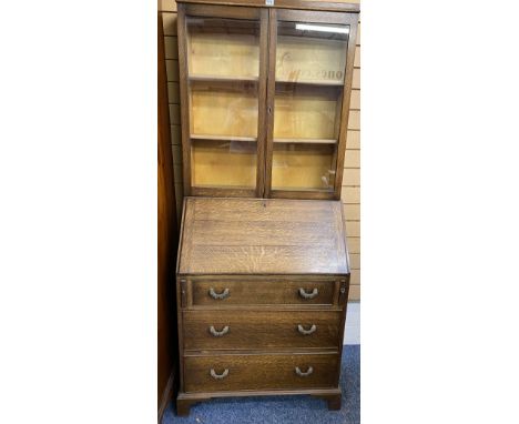 VINTAGE OAK BUREAU BOOKCASE having twin glazed doors over a pigeon hole interior and fall front with three long drawers on co