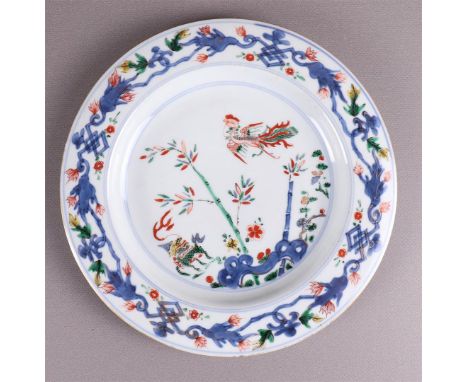 A porcelain dish, China, Kangxi, around 1700. Polychrome decor of a.o. phoenix with temple lion near rocks with bamboo on the