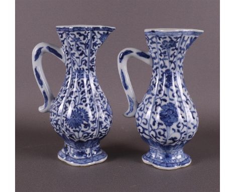 A pair of blue and white porcelain jugs, China, Kangxi, around 1700. Blue underglaze floral decor, h 14 cm, tot. 2x (restorat