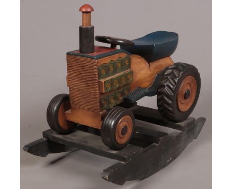 A painted hardwood rocking tractor. H: 71cm, L:79cm, D:44cm.  Condition good. A few paint scuffs.