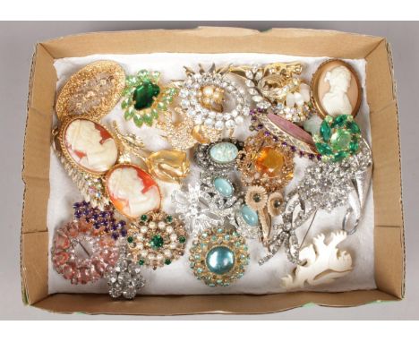 A box of vintage costume brooches. Including paste, rhinestone, cameo examples, etc.  One white paste brooch missing stone.