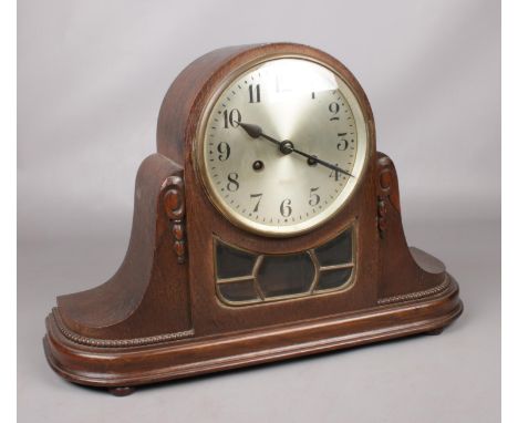 A carved mahogany eight day chiming mantle clock with silvered dial. Pendulum and key present.  