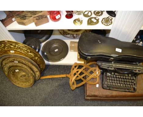 A vintage metal travel trunk, well travelled; an Underwood typewriter; a violin case; brass chargers; carpet beater; etc