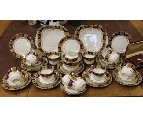 An Edwardian twelve place tea service decorated with leaves and flowers.