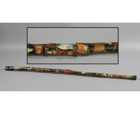 A folk art walking stick painted with animals.