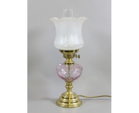 A brass based electric oil lamp with coloured glass font.