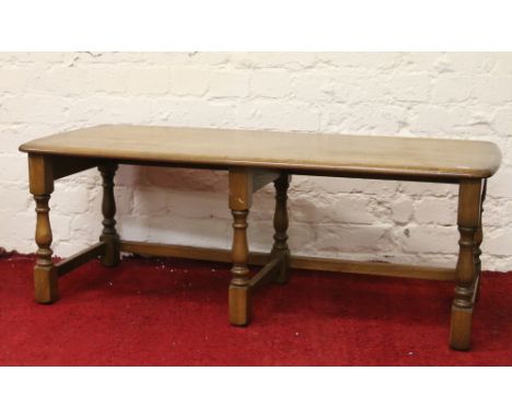 An Ercol light elm coffee table raised on turned legs.