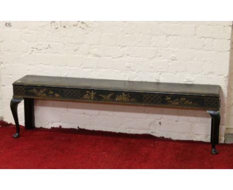 A Victorian wooden bench with Japanned decoration and raised on cabriole supports.