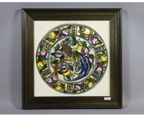 A framed ceramic plaque, tube lined and decorated with fruit and pheasant.