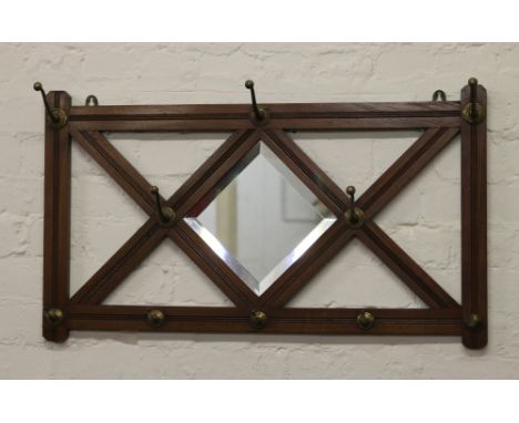 A mahogany framed wall mirror and coat rack.