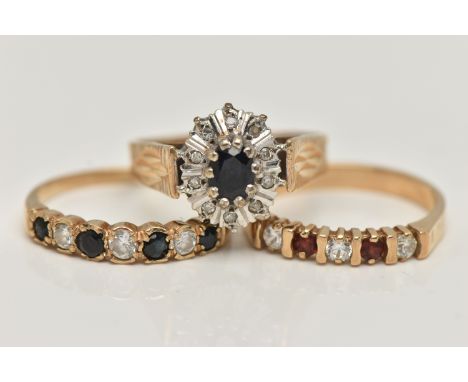 THREE 9CT GOLD GEM SET RINGS, the first a sapphire and diamond cluster ring, the second a seven stone sapphire and colourless