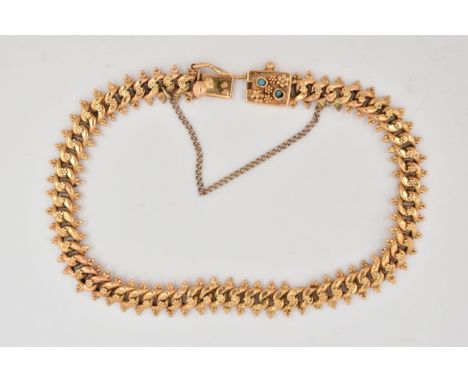A FANCY LINK BRACELET, the curb link bracelet with beaded floral detail to the central links and beaded trefoil detail to the