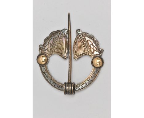 AN IRISH SILVER PENANNULAR CELTIC BROOCH, designed as two harps with yellow metal embellishments, approximate width 61mm, hal
