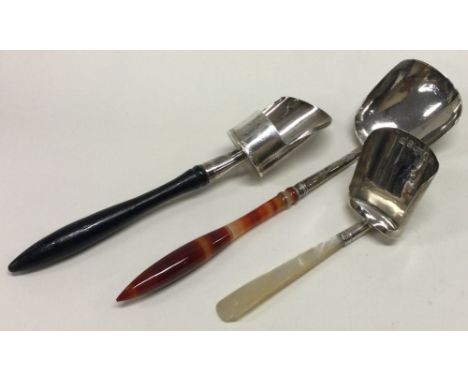 Three silver caddy spoons with shovel bowls and hard stone / MOP / ebony handles. Various dates and makers. Approx. 40 grams.