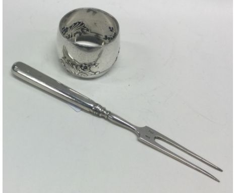 An Antique silver steak fork together with a Continental napkin ring. Approx. 72 grams. Est. £25 - £30.