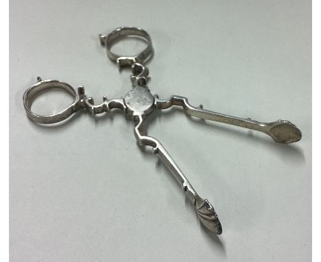 A pair of 18th Century silver tongs. Maker's mark and lion only. Approx. 38 grams. Est. £30 - £50. 