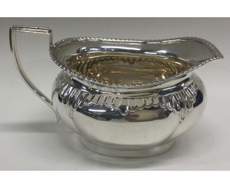 An Edwardian silver cream jug with fluted rim. Approx. 109 grams. Est. £40 - £60.