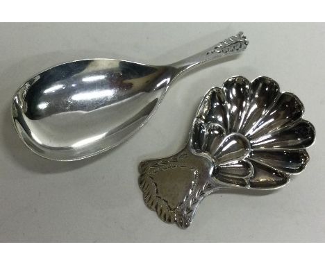A good Georgian style silver caddy spoon with fluted bowl together with one other. Approx. 29 grams. Est. £20 - £30.