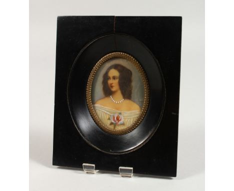 AN OVAL PORTRAIT MINIATURE, young lady wearing a white dress with a rose, signed, in an ebony frame. 6ins x 4.75ins.