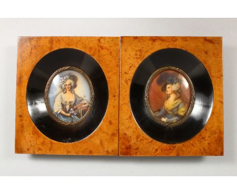A PAIR OF OVAL PORTRAIT MINIATURES, young lady wearing 18th century style dresses and hats, in burr wood frames. 5.25ins x 4.