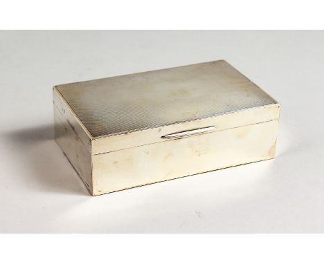 AN ENGINE TURNED SILVER CIGARETTE BOX, with cedar wood liner. 5.5ins long.  Birmingham 1902.
