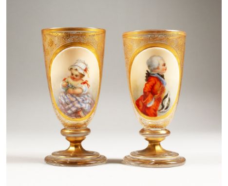 A GOOD PAIR OF 19TH CENTURY GILDED GLASS PEDESTAL GOBLETS, one painted with a three-quarter length portrait of a young boy we