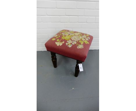 A Victorian mahogany foot stool having a tapestry floral top raised on turned supports