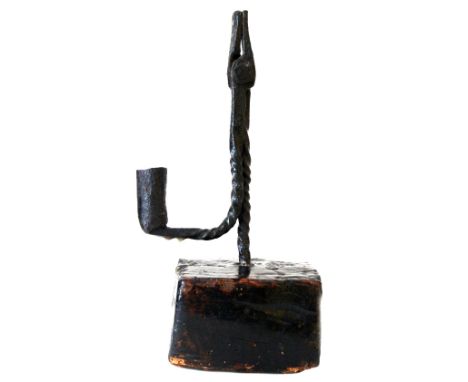 A wrought metal rush light, with spiral column and arm, on a stained and polished pine base, 25.5cm high.
