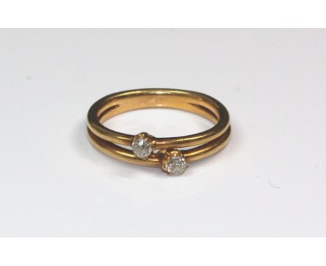 An early 20th century gold and diamond two stone ring, the small old-cut diamonds each claw set in a cross-over design on a t