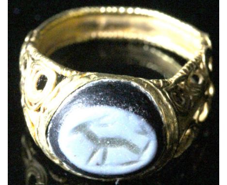A Roman gold and glass imitation nicolo intaglio 4th-5th Century AD, the hoop composed of ribbed band boarded by gold wire, s