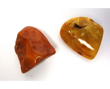 Two 'butterscotch' amber boulders, each with a flat side, one of light colour measures approximately 5.8cm high and weighs 40