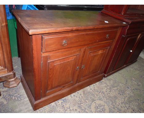 A compact Mahogany Sideboard having a full with frieze drawer and a pair of opposing raised and fielded panelled doors below,