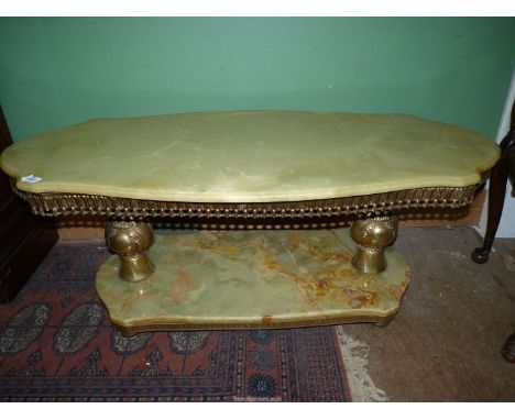 A heavy shaped Onyx topped coffee table having a lower shelf and brass/Ormolu bulbous supports and friezes, 47 1/2'' long x 2